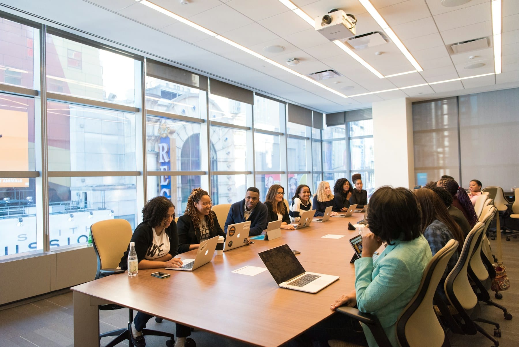 A leadership team in session around a long boardroom table.