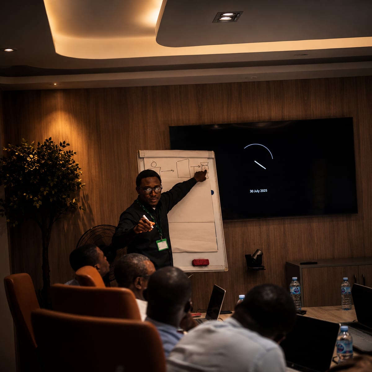 A facilitator working through a diagram on a flip chart with participants seated.